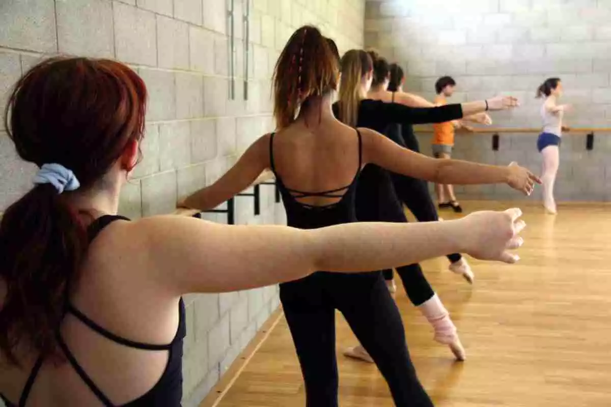 Diverses noies i un noi a un classe de ballet clàssic