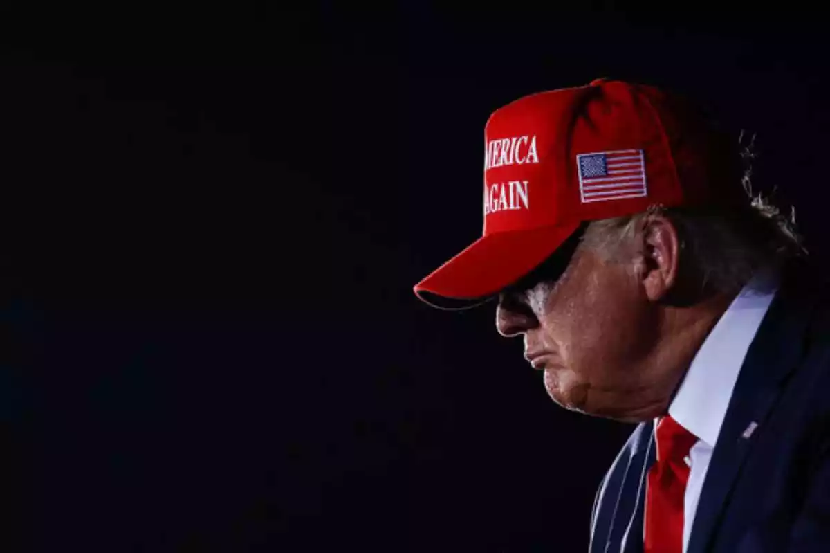 Donald Trump, amb una gorra amb el lema 'Make America Great Again' i el fons fosc