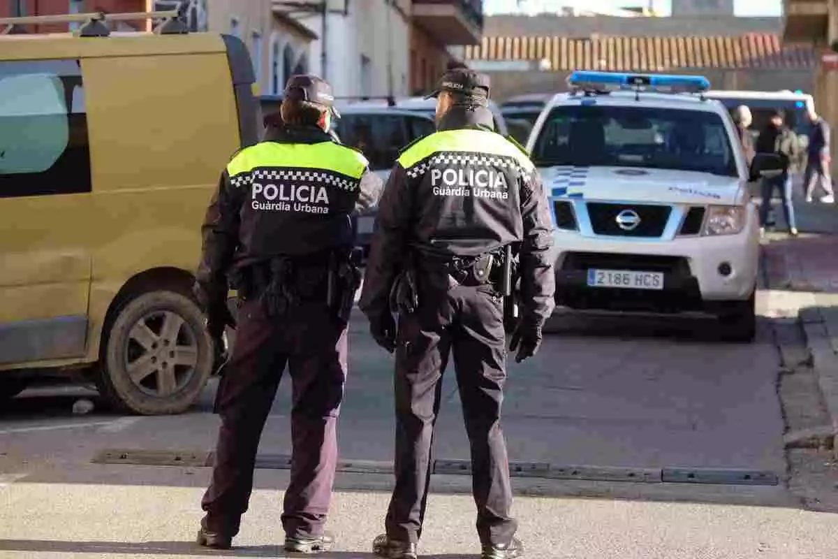 Dos agents de la Guàrdia Urbana de Figueres patrullant en un carrer de la ciutat