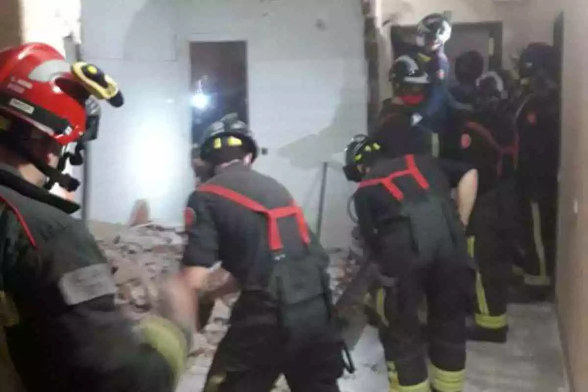 Efectius dels Bombers de Barcelona treballen a les runes d'un pis del carrer Calàbria després d'una explosió