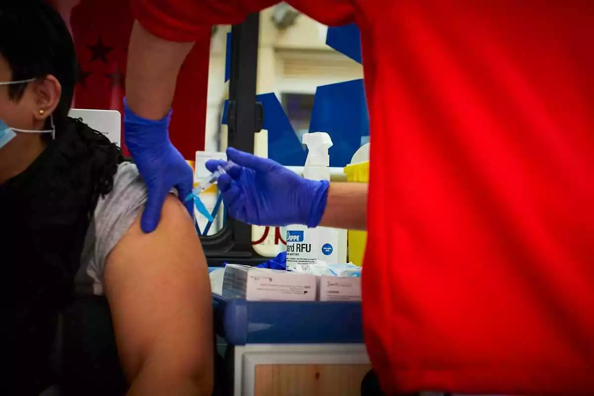 Personal sanitari aplicant la vacuna de la grip a un pacient