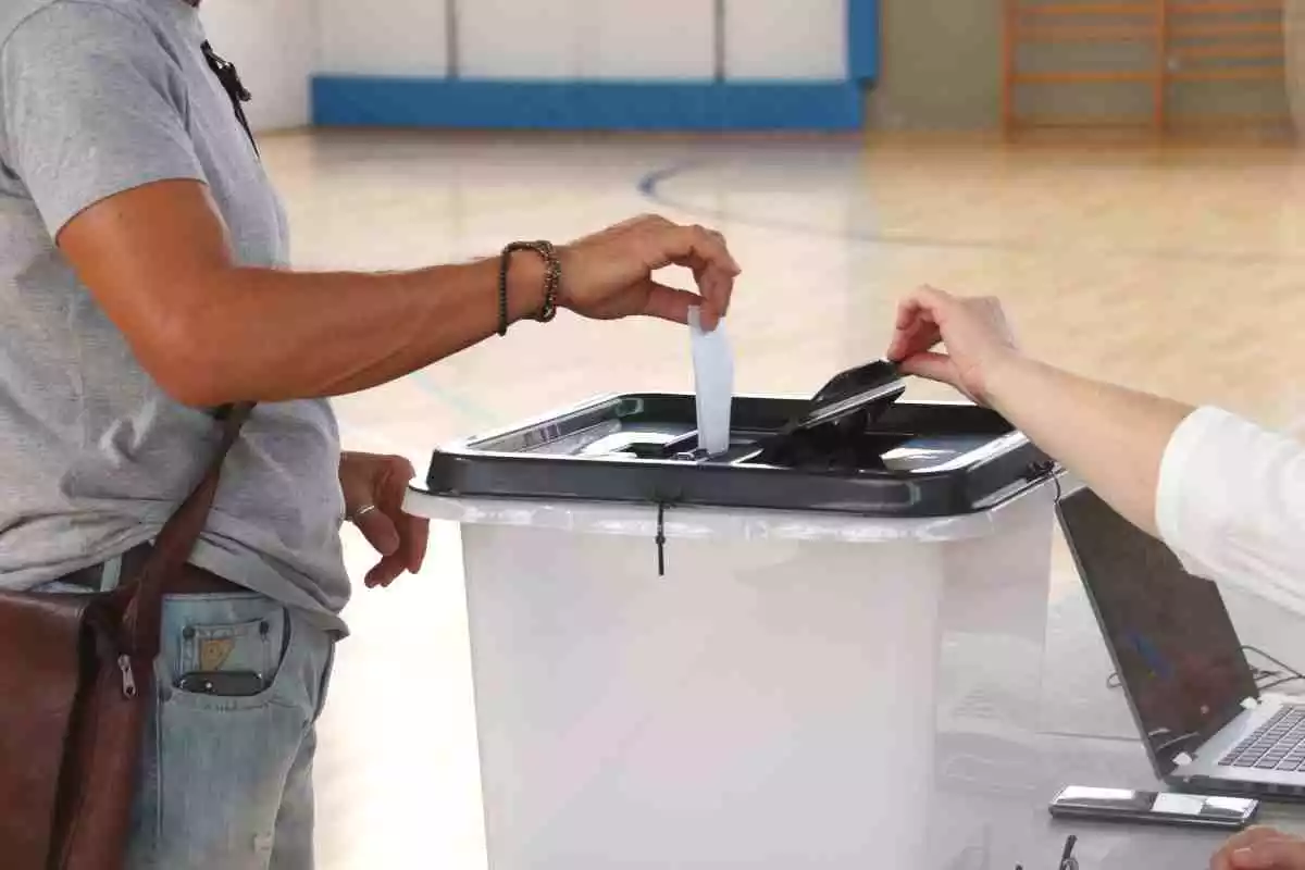 Un home dipositant un vot en una urna