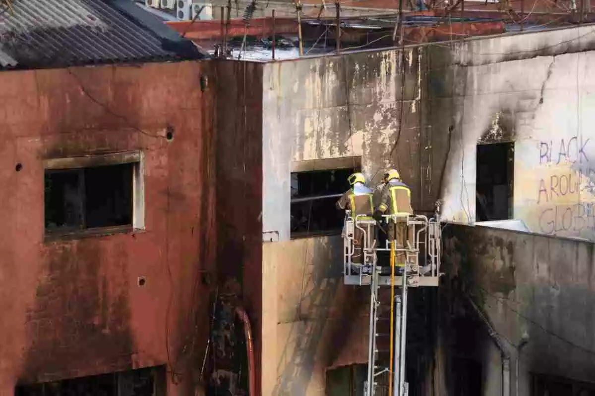 Els Bombers remullen l'interior de la nau cremada al barri del Gorg de Badalona, el 10 de desembre de 2020