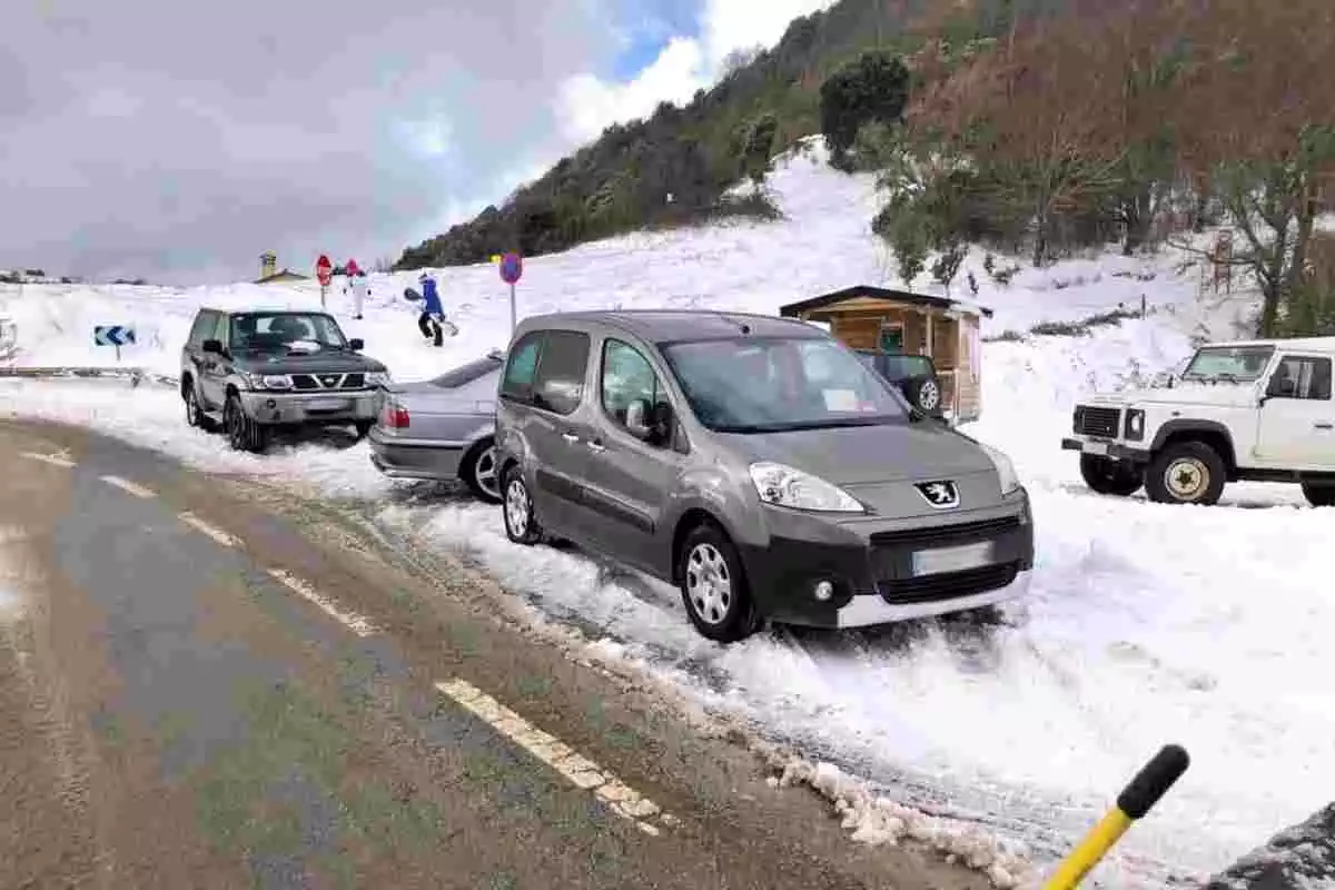 Diversos vehicles aparcats a la neu per visitants d'altres municipis, al Montseny