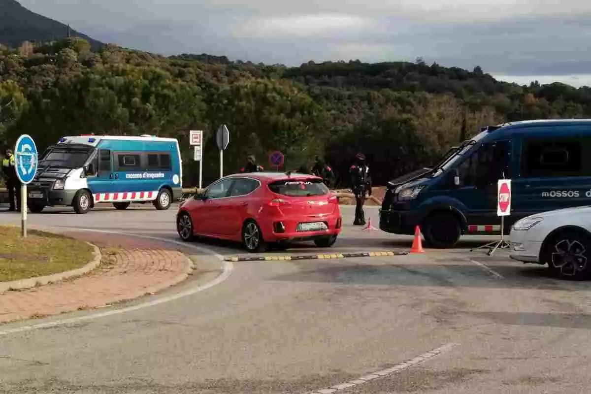 Dos vehicles dels Mossos i un cotxe vermell durant un control policial