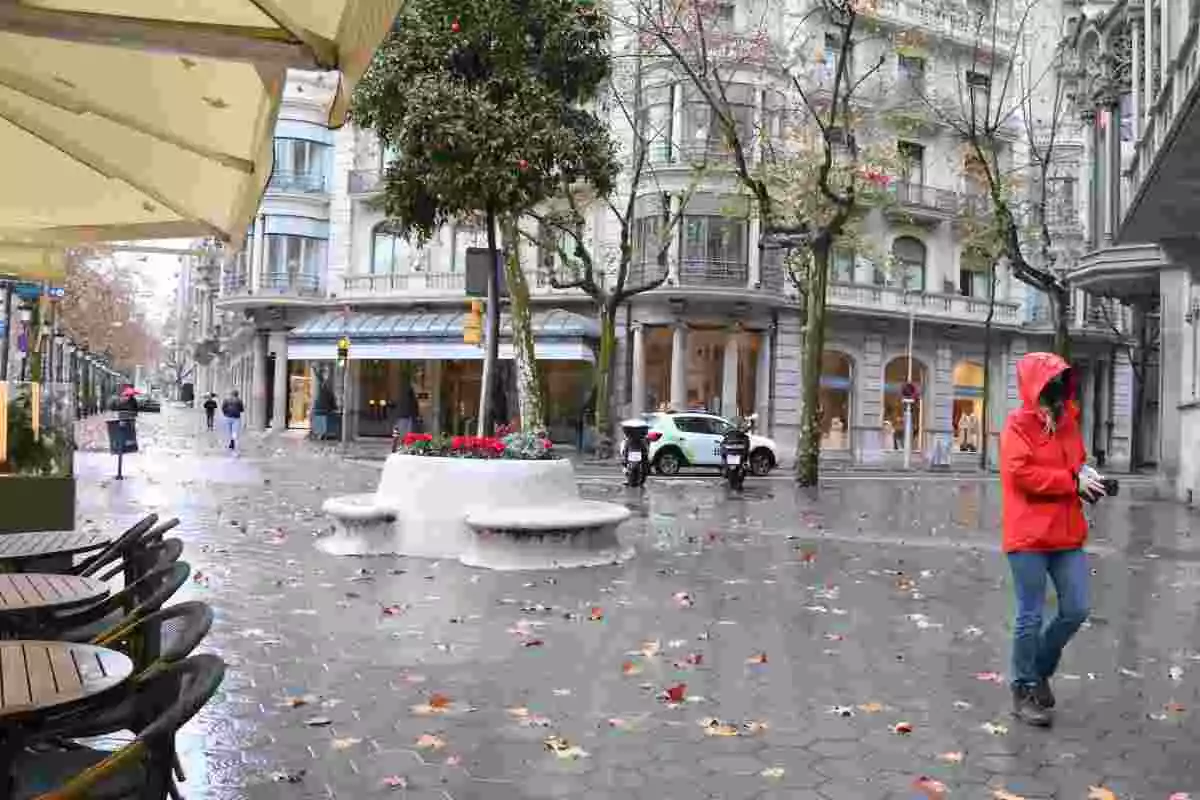 El passeig de Gràcia buit amb una terrassa sense gent i amb molt poca gent caminant pel carrer. 9 de gener del 2021