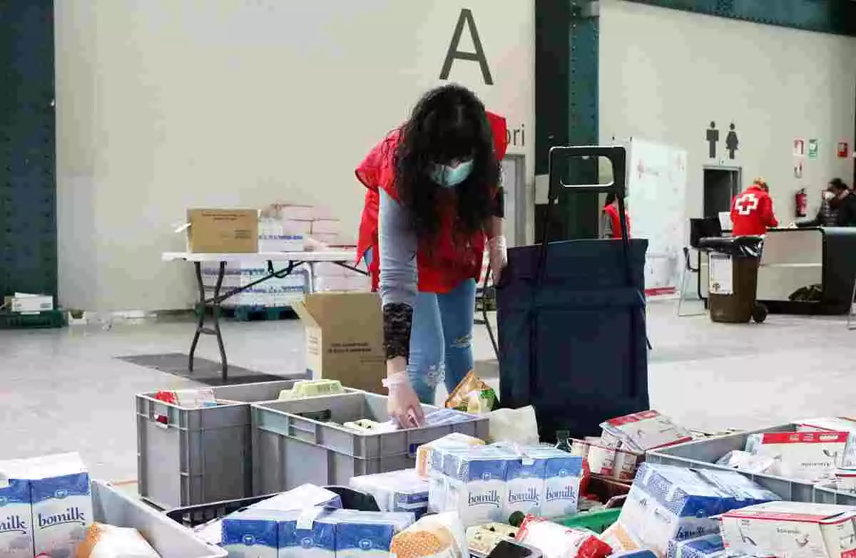 Imatge d'una voluntària de Creu Roja Sabadell preparant lots del Rebost Solidari el 23 de març de 2020