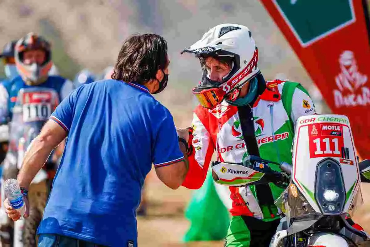 Pierre Cherpin, damunt la seva moto, saluda el director del Dakar, David Castera, en l'etapa pròleg d'aquesta edició