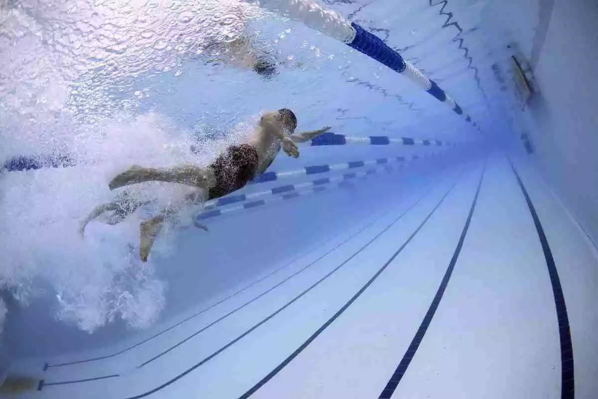 Un home practica natació en una piscina