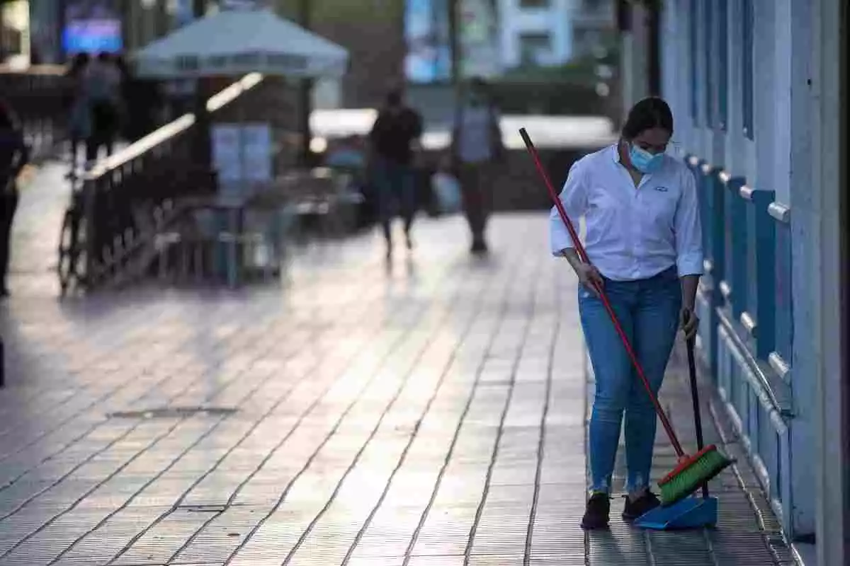 Una dona escombrant una terrassa buida durant les restriccions a Espanya