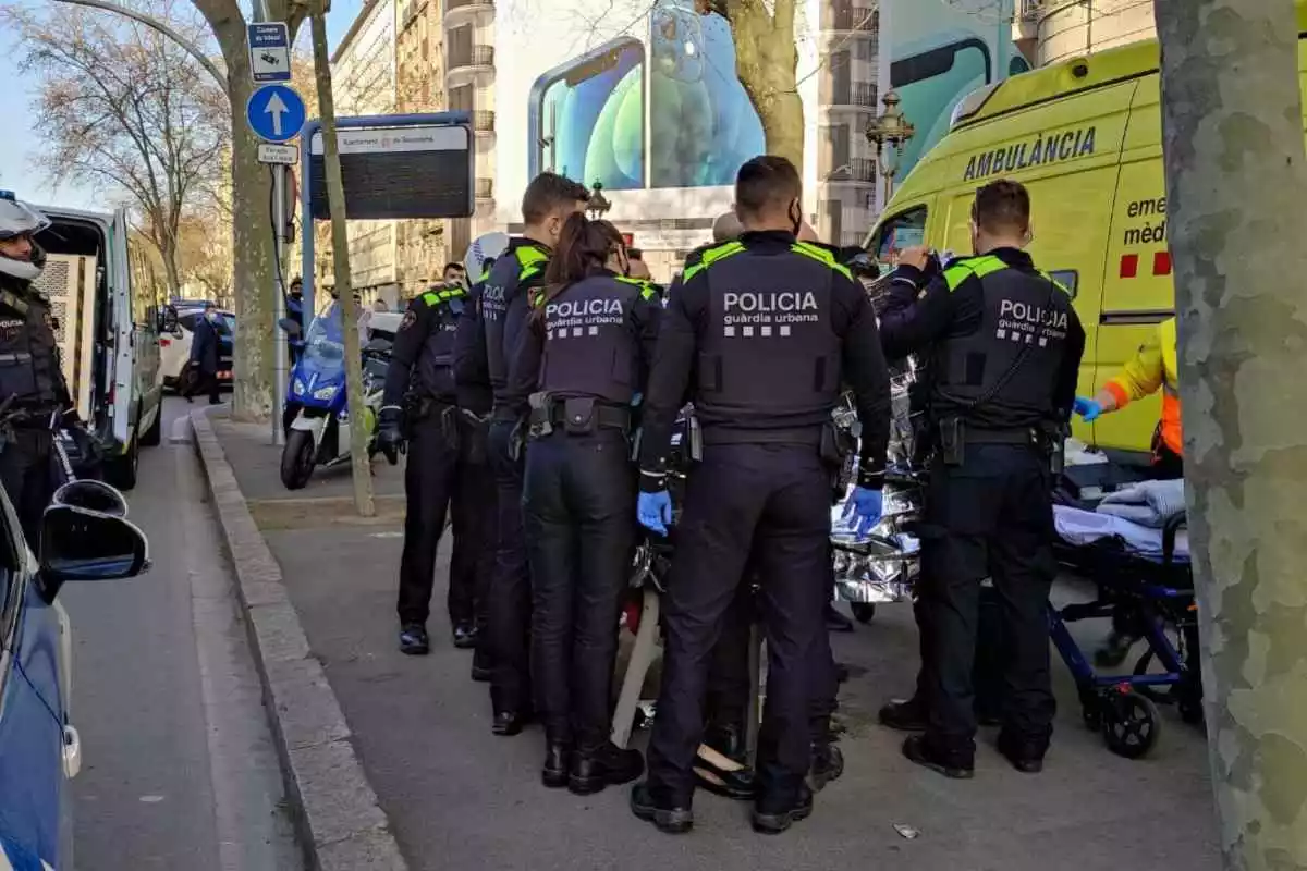 Agents de la Guàrdia Urbana de Barcelona i el SEM traslladant la mare i el nadó a l'hospital