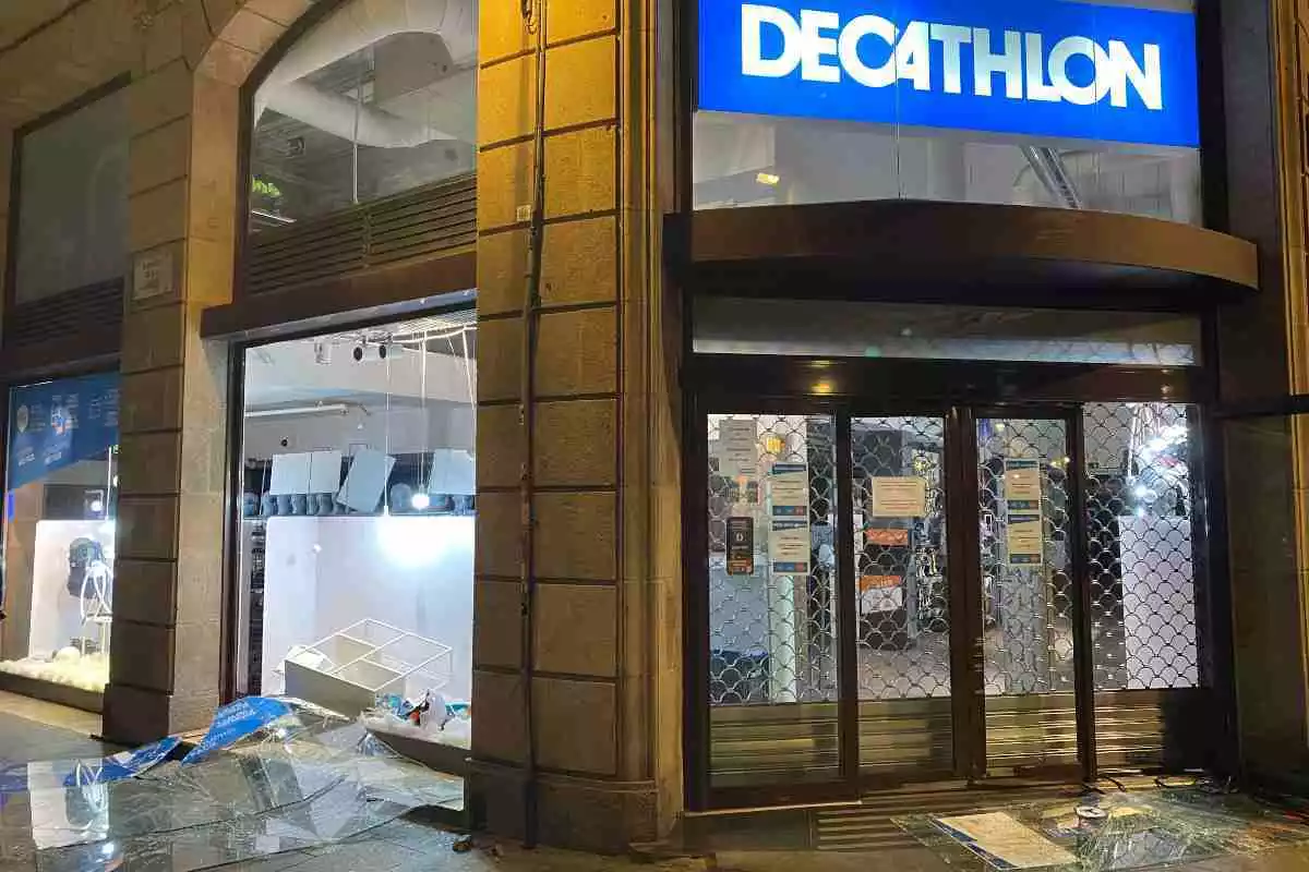 Aspecte d'una botiga Decathlon de Barcelona amb els aparadors trencats durant la quarta nit de protestes per l'empresonament de Pablo Hasel. 19 de febrer del 2021.