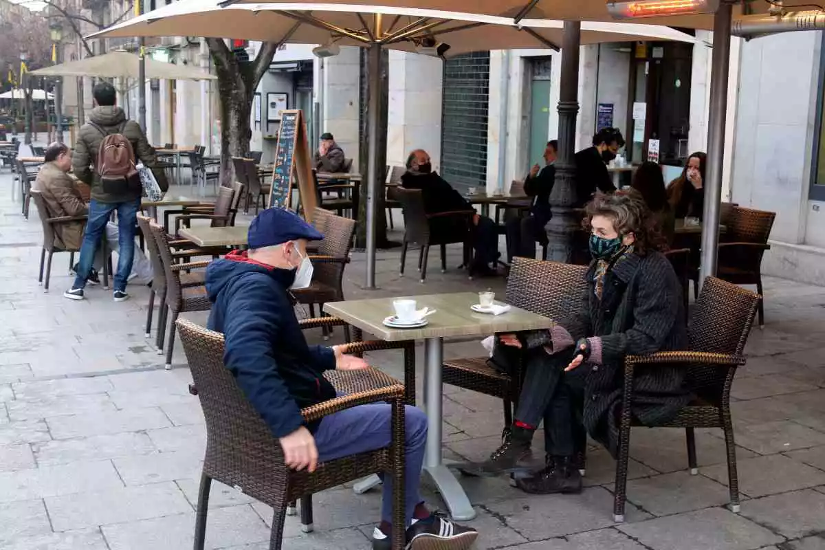 Clients esmorzant en una terrassa de la Rambla de Girona