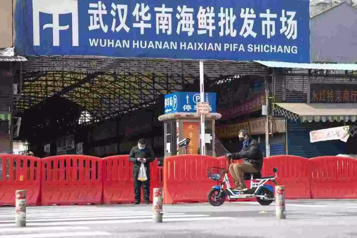 Dos ciutadans davant de l'entrada del mercat de Huanan a Wuhan (Xina)