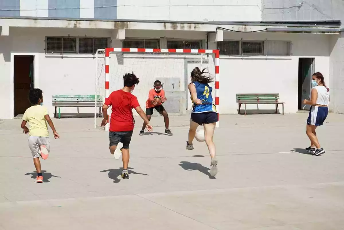 Imatge de cinc joves jugant a futbol sala en una escola de Catalunya