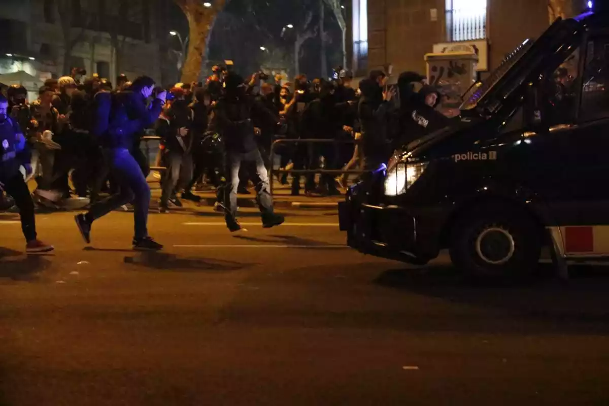 Manifestants davant d'una furgoneta dels Mossos d'Esquadra durant els aldarulls a Barcelona