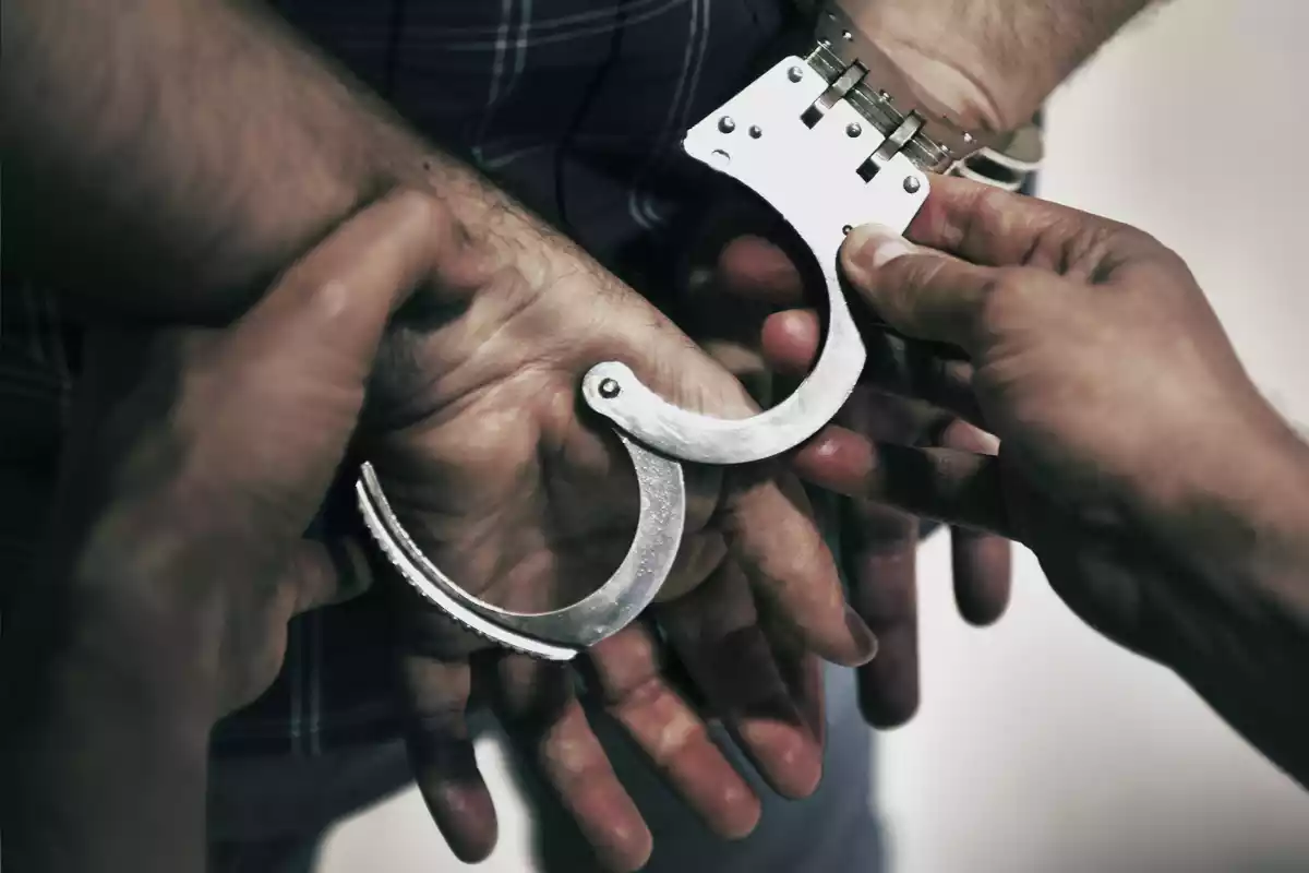 Un agent dels Mossos durant la detenció d'un sospitós amb les mans immobilitzades