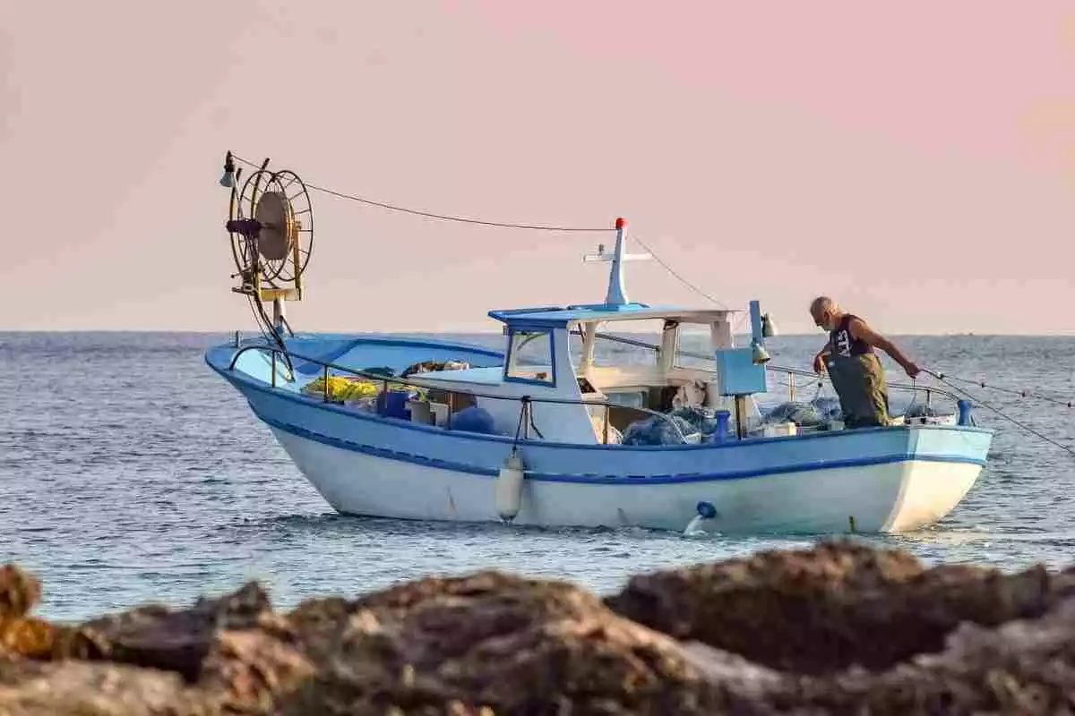Un home pescant amb la seva barca