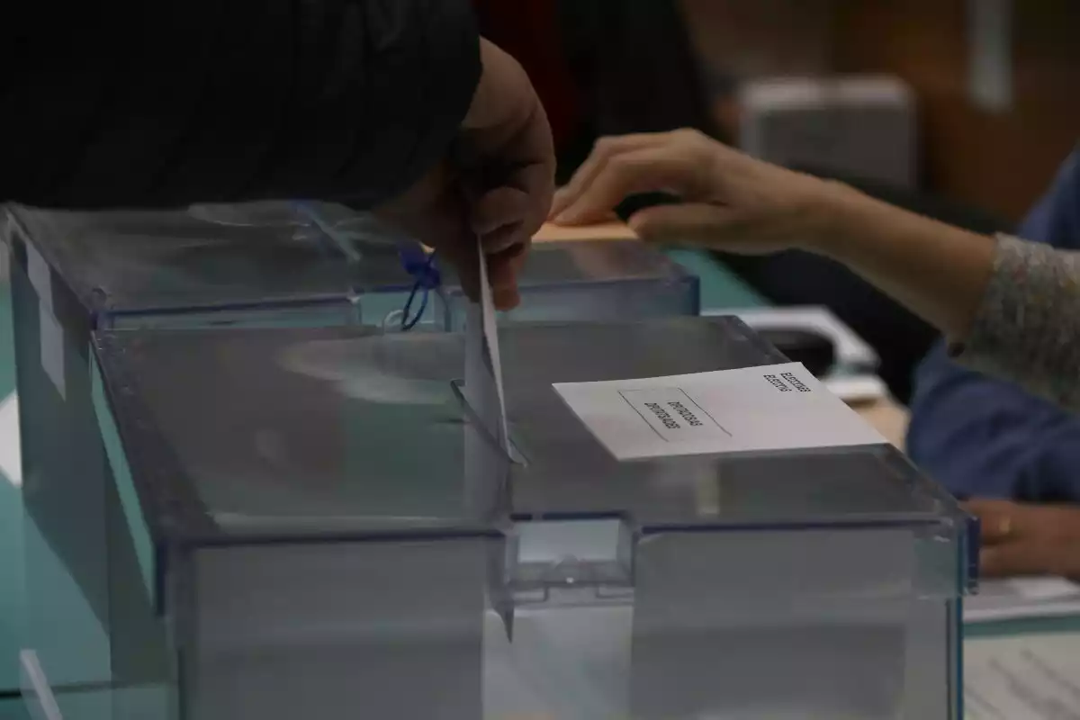 Una persona introduint el sobre amb el seu vot a l'urna electoral el 10-N de 2019