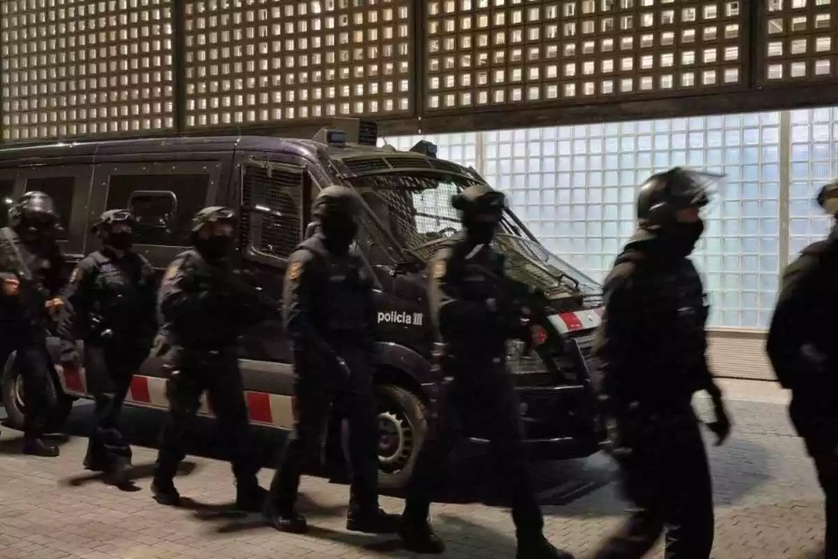 Diversos agents dels Mossos d'Esquadra davant un cotxe policial en un operatiu antidroga
