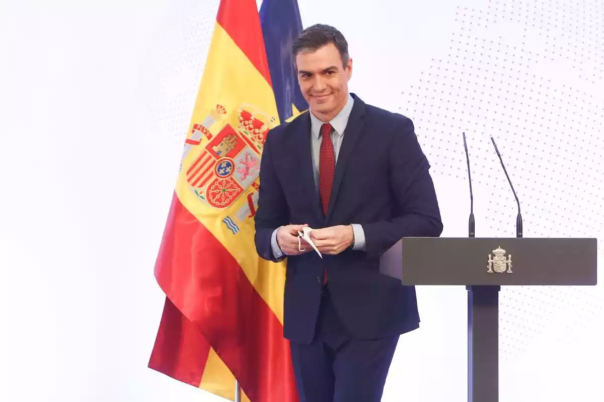 El president espanyol Pedro Sánchez amb una bandera nacional i una altra de la UE darrere