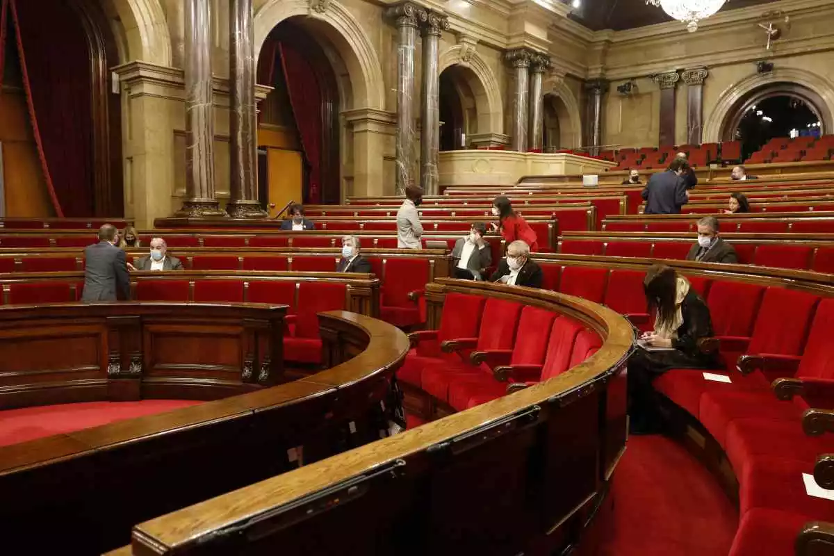 Pla general del Parlament de Catalunya amb pocs parlamentaris asseguts i mascareta posada