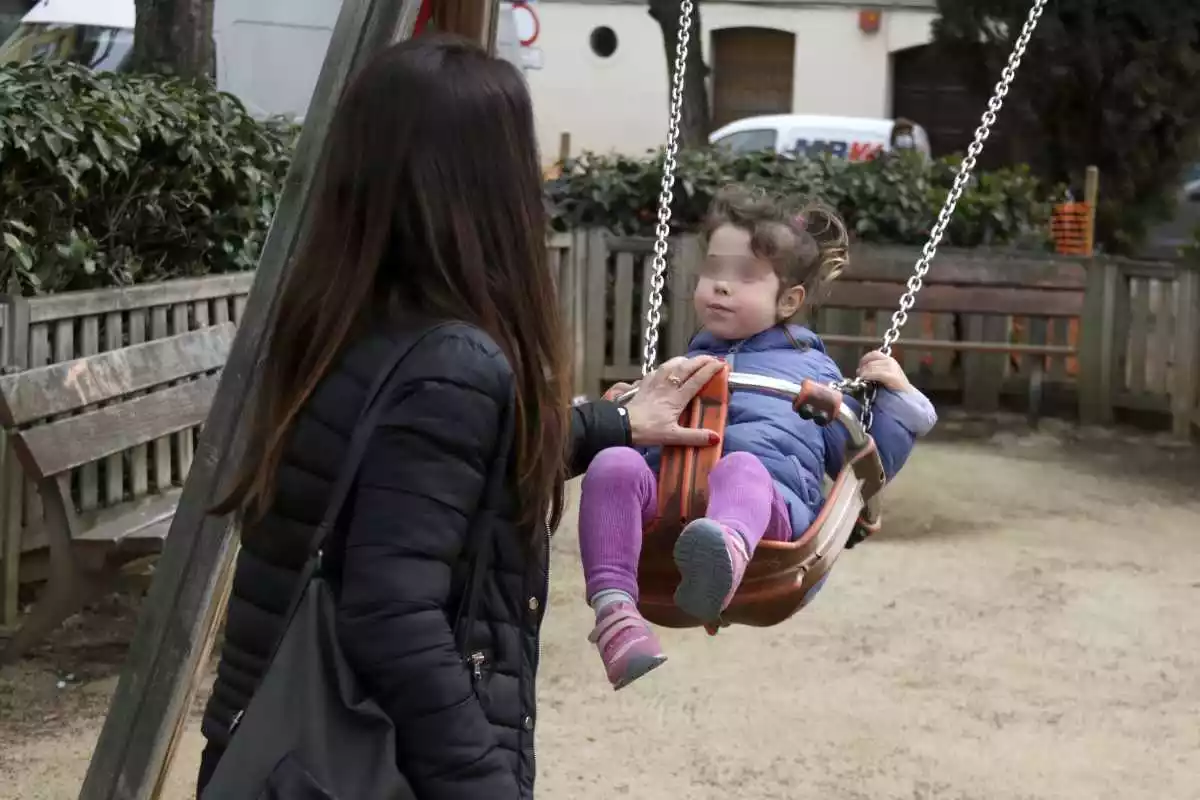 Una mare gronxa la seva filla, a Mataró, el dia que s'han reobert els parcs infantils