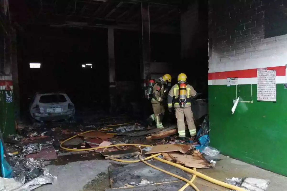 Efectius dels Bombers treballen en l'extinció d'un incendi en un taller mecànic de Manresa el 16 d'abril del 2021.