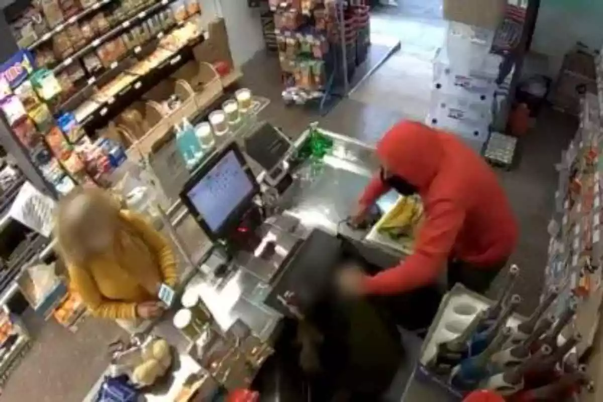 Imatge de l'atracament d'un home a una botiga