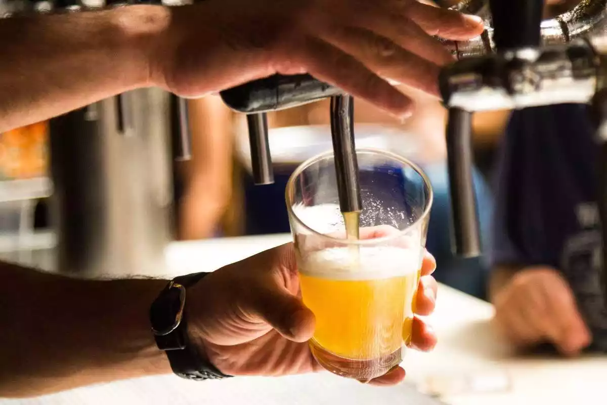 Imatge d'un cambrer servint un got de cervesa