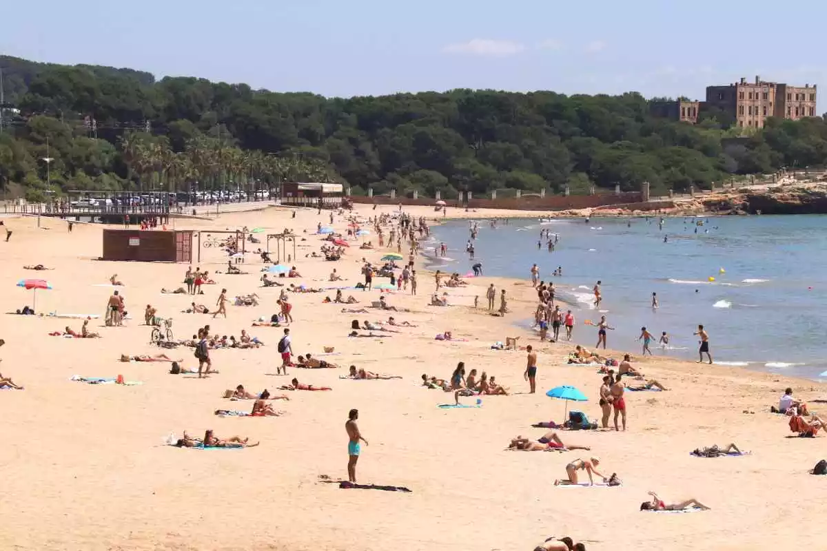 Pla general de la platja de l'Arrabassada de Tarragona, amb banyistes i gent prenent el sol