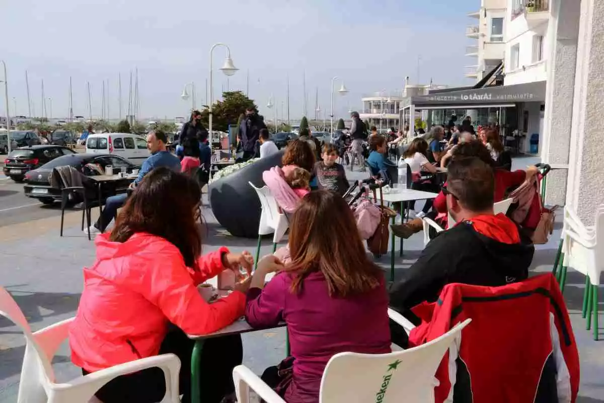 Pla general de persones consumint en una terrassa d'un bar de la zona marítima de l'Ampolla aquesta Setmana Santa (03/04/2021)