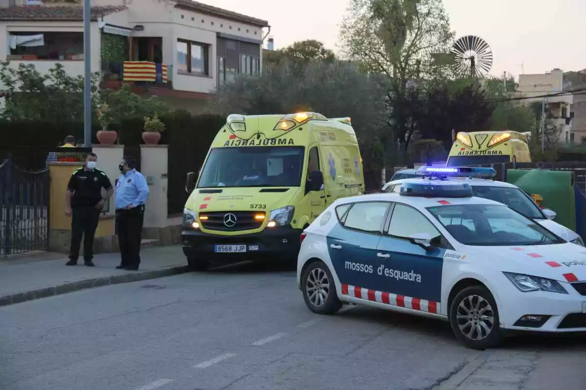 Pla mitjà de la Policia Local i els Mossos amb les ambulàncies del SEM en un carrer de la Bisbal d'Empordà