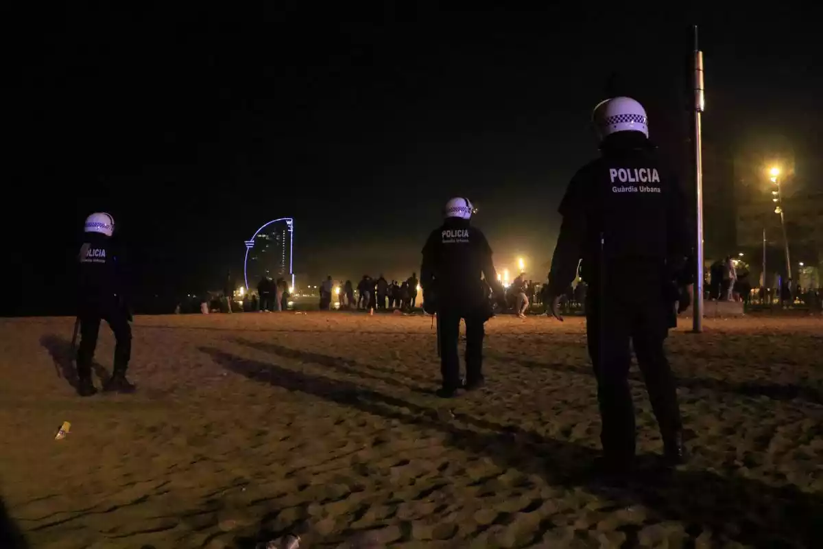Agents de la Guàrdia Urbana de Barcelona a la sorra de la platja de Sant Miquel, a la Barceloneta