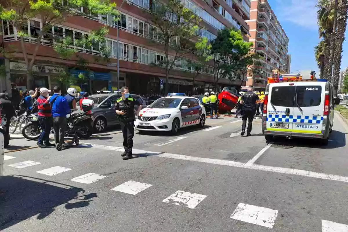 Imatge de l'accident de cotxe que ha tingut lloc a Barcelona, amb el vehicle bolcat al fons