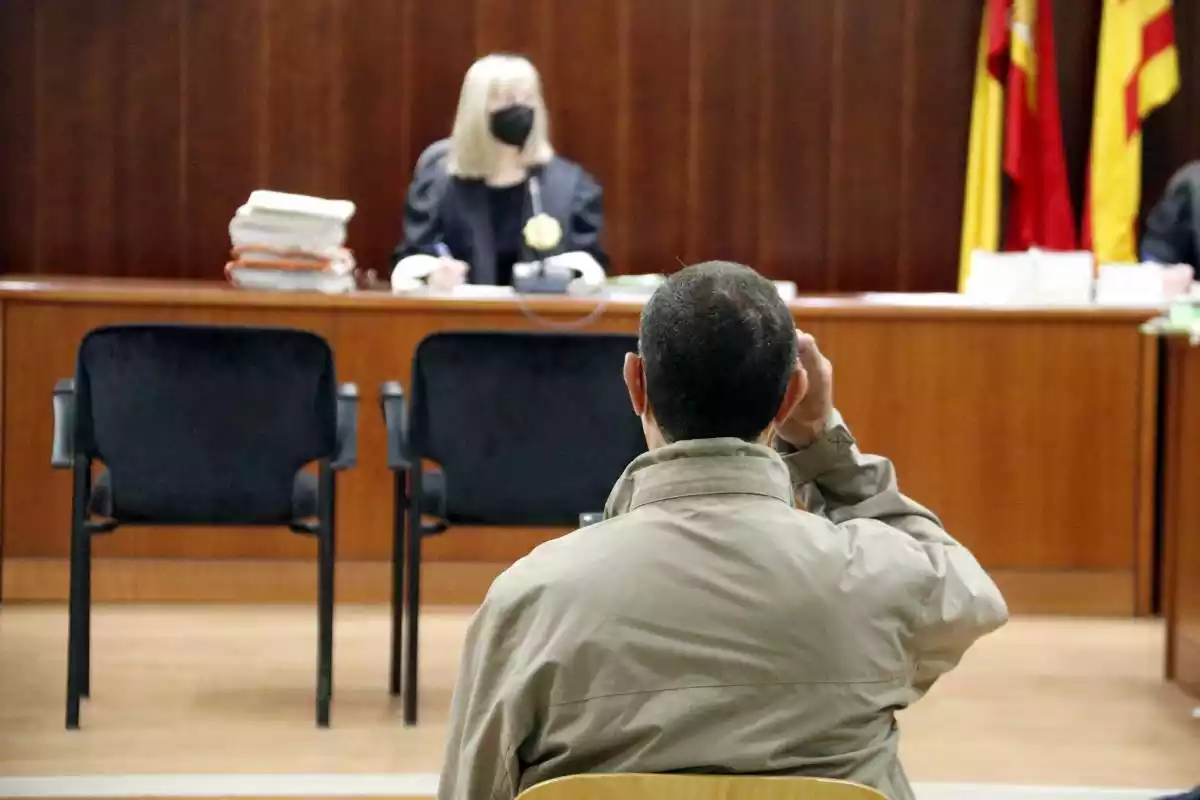 Pla tancat d'esquenes de l'acusat de violar la seva neboda, assegut a l'Audiència de Lleida durant el judici