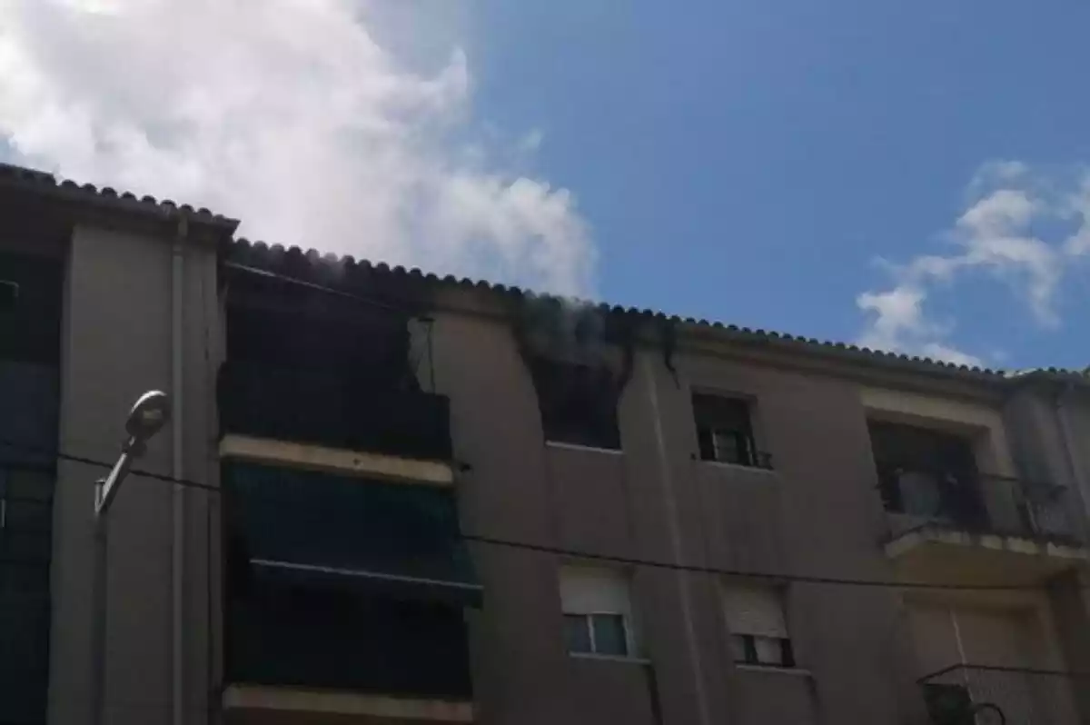 Fum sortint de la finestra d'un habitatge on s'ha generat un incendi