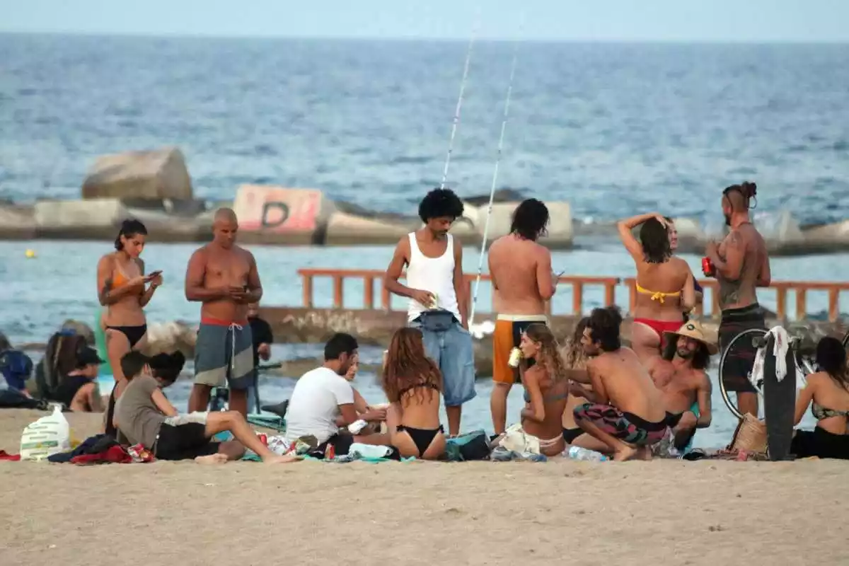 Imatge d'un grup de persones fent una trobada a la plaja de la Barceloneta.