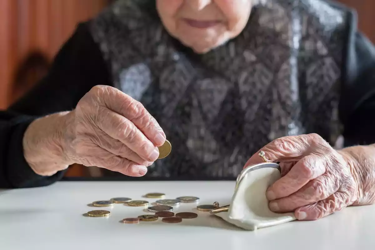 Pla de les mans d'una dona gran comptant monedes