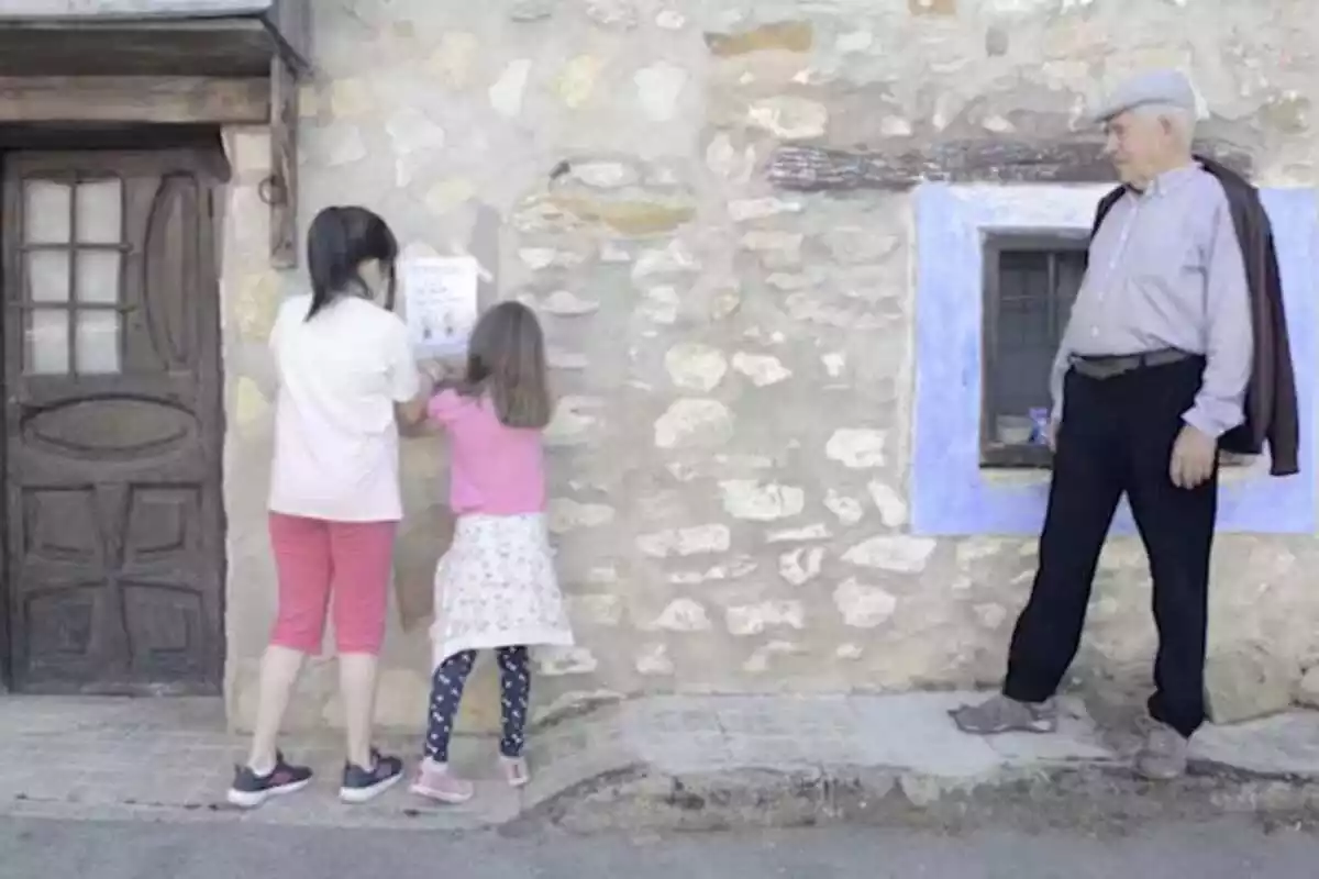 Dues nenes i un senyor del poble de Grecs al vídeo promocional