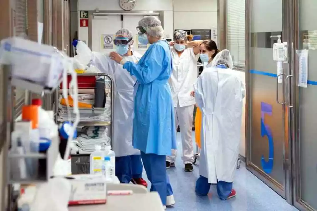 Imatge de diversos treballadors de la sanitat vestint-se amb EPIs.