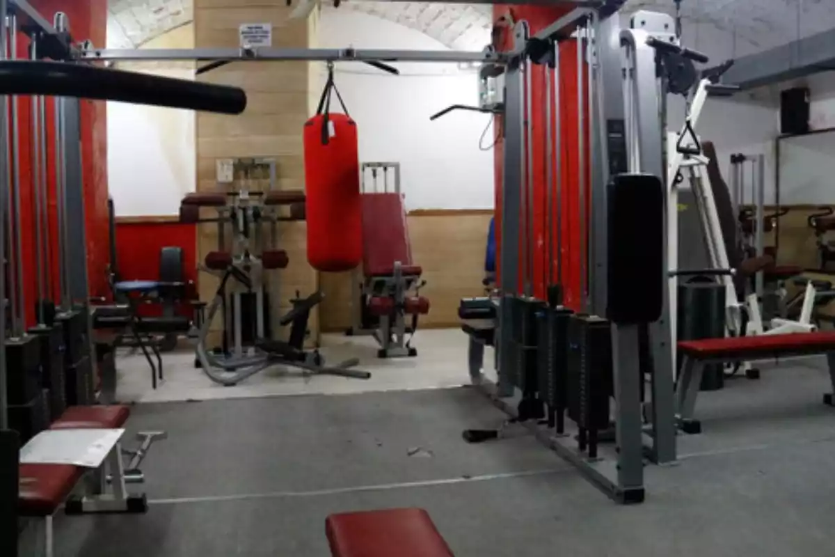 Imatge d'un gimnàs buit amb diferents màquines per fer exercicis