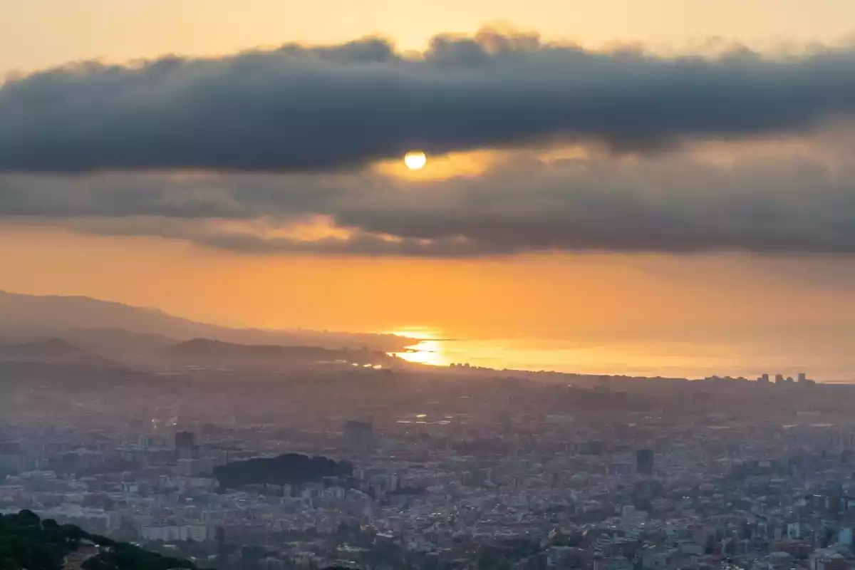 Imatge d'una sortida de sol entre núvols a Barcelona