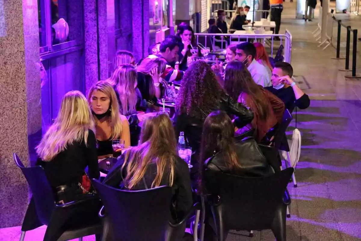 Imatge d'una terrassa de bar a Sitges, al Garraf, a la nit, on s'hi poden veure molts nois i noies joves