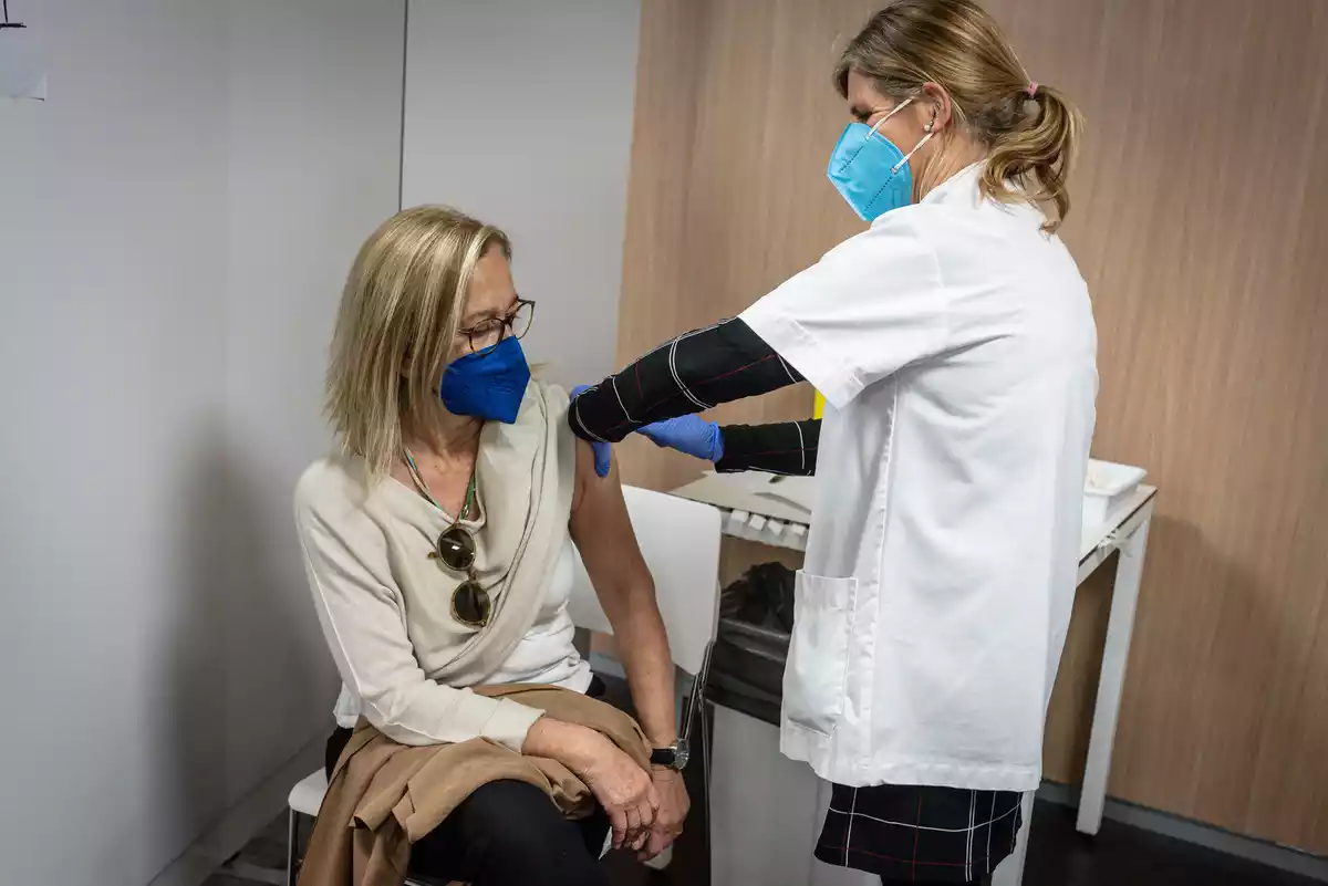 Una dona vacunant-se contra la Covid-19 per una enfermera