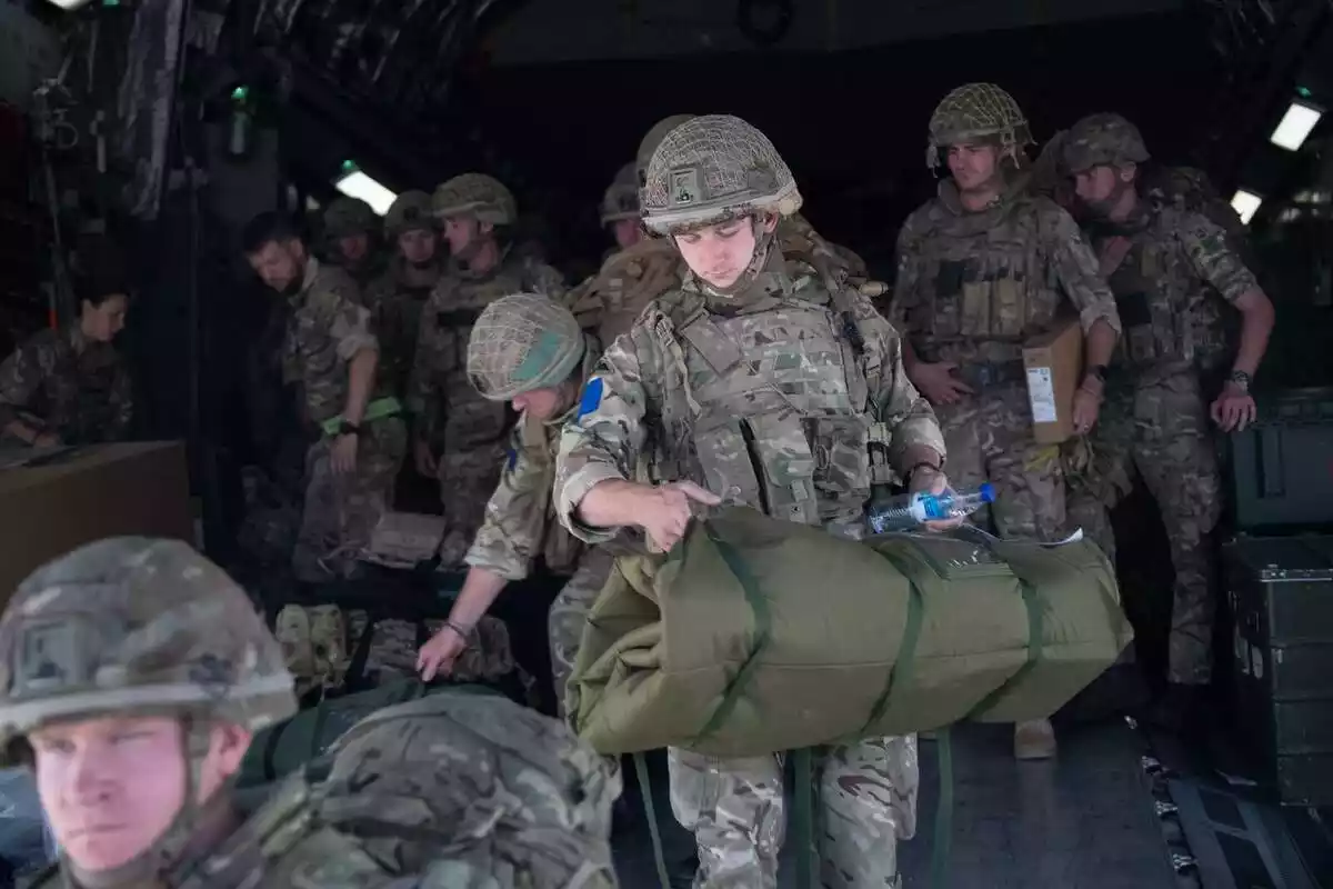 Diversos soldats bixant d'un avió militaritzat amb material