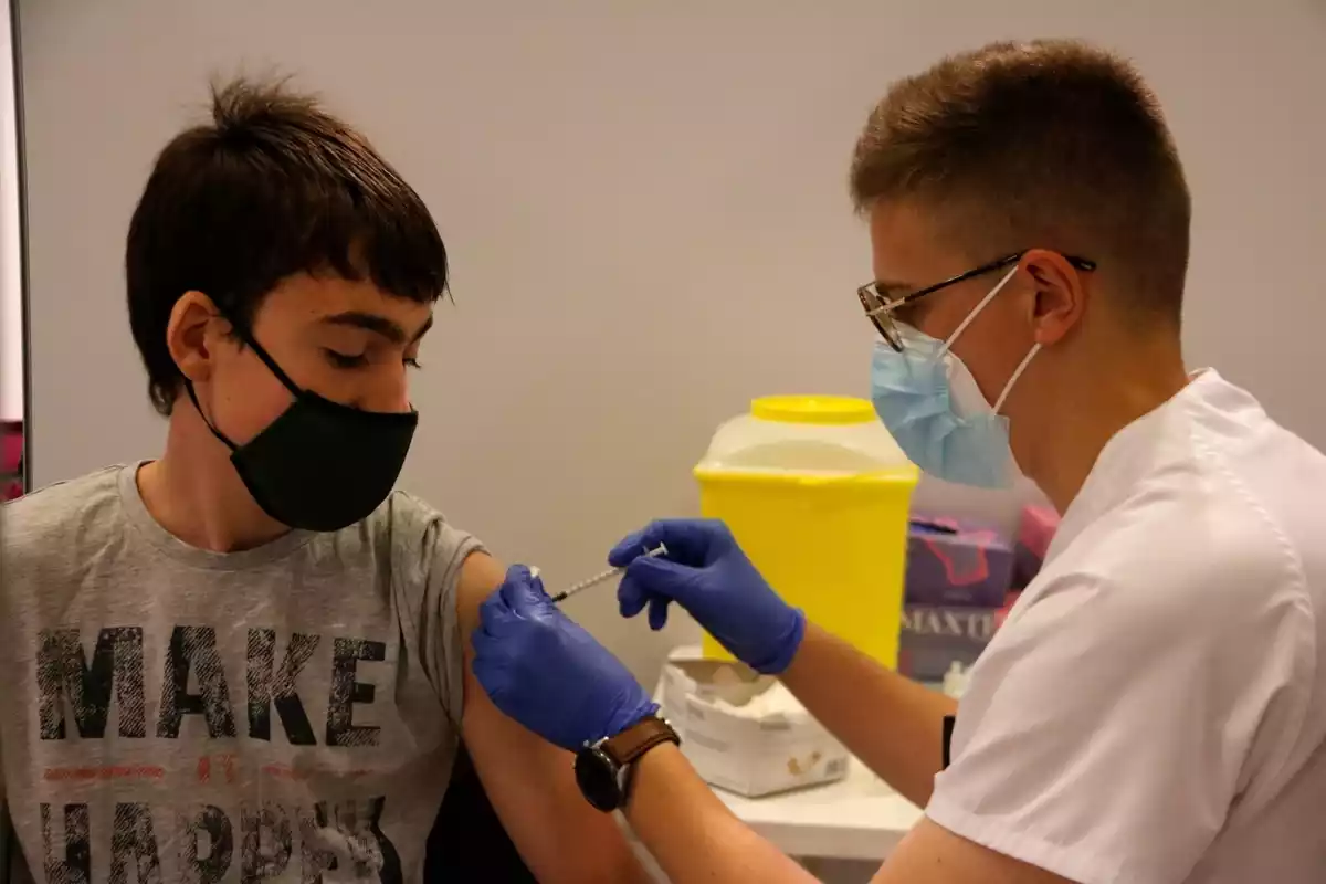 Pla mitjà d'un adolescent rebent la vacuna a Manresa
