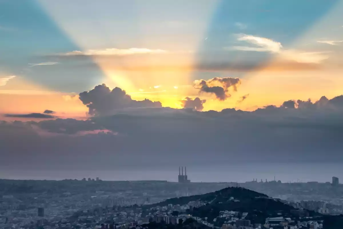 Imatge d'una sortida de sol entre núvols a Barcelona
