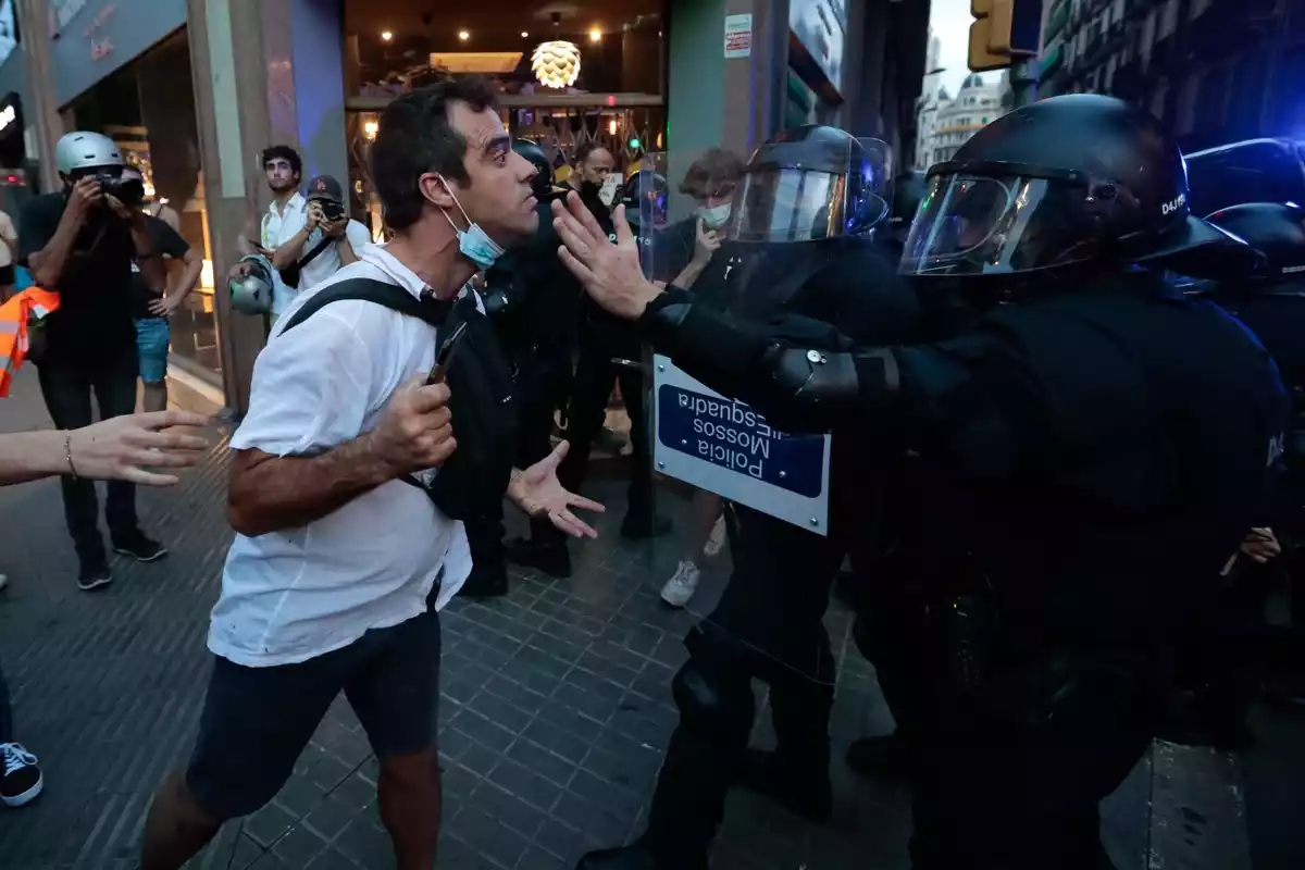 Un manifestant s'encara a un agent dels Mossos d'Esquadra a l'entorn de la comissaria de la Policia Nacional de la Via Laietana de Barcelona
