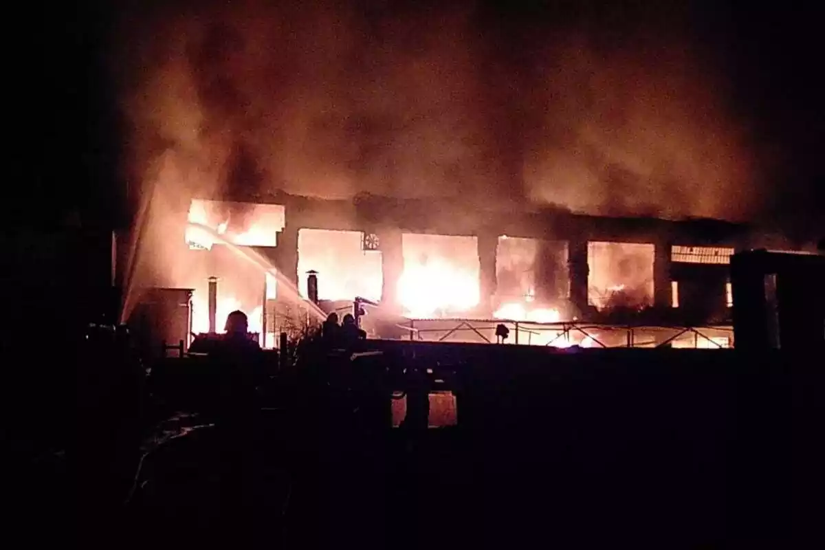 Flames cremant una fàbrica de nit a Sentmenat